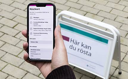 Digitalt röstkort och skylt med text: "Här kan du rösta"