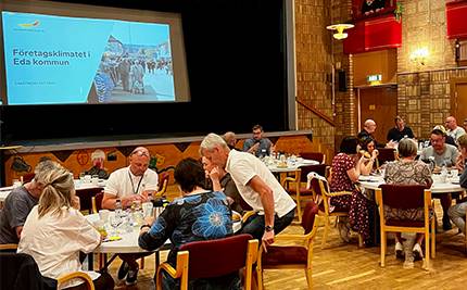 Lunchmöte för företagare, en samling personer vid bord framför stor skärm